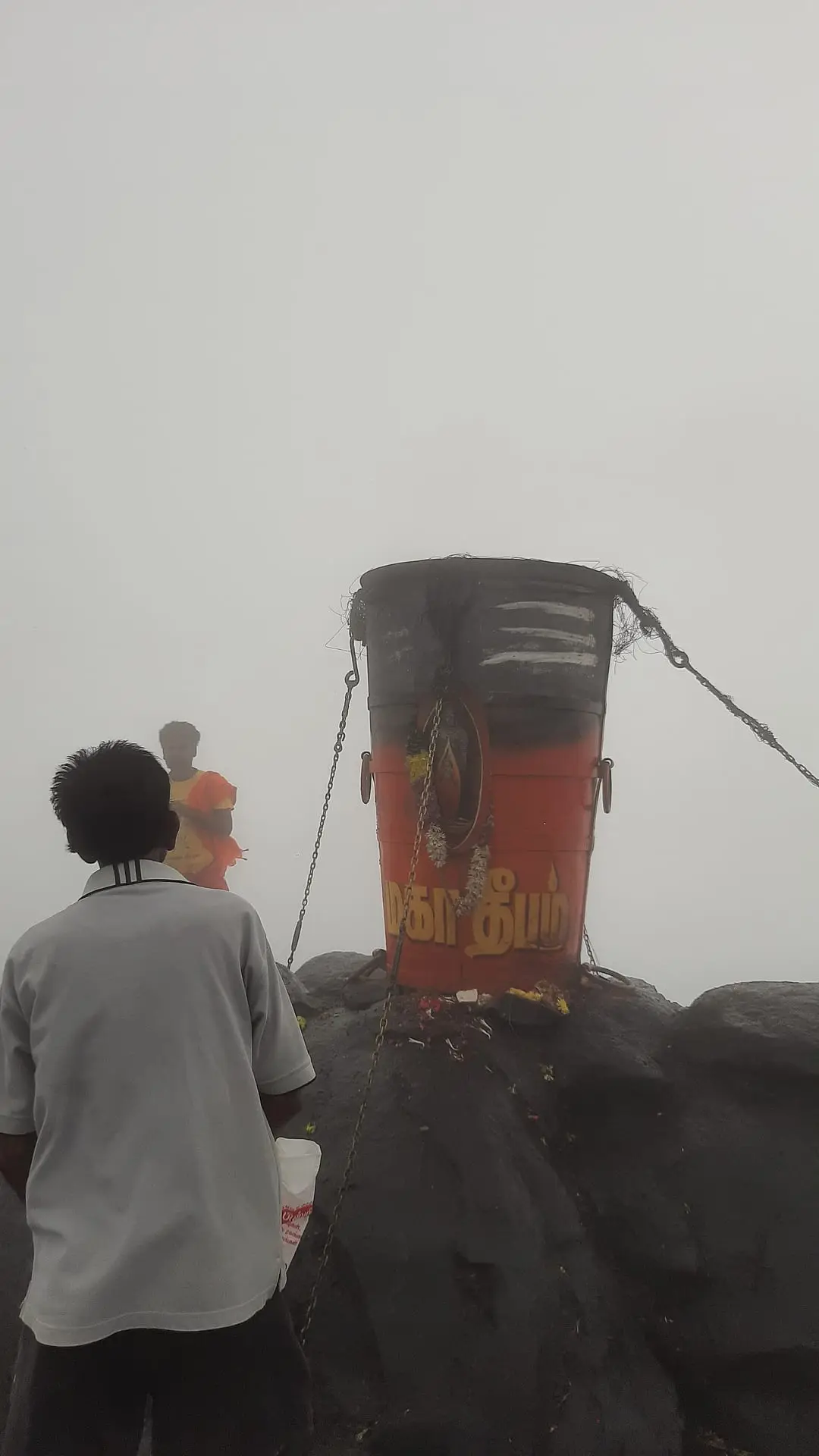 The Maha Deepam cauldron on the summit of Arunachala hill, wrapped in mist