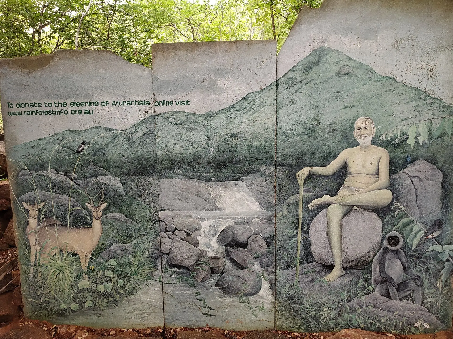 A painted mural of Ramana Maharshi seated before Arunachala, beside the path to Virupaksha Cave and Skandashram